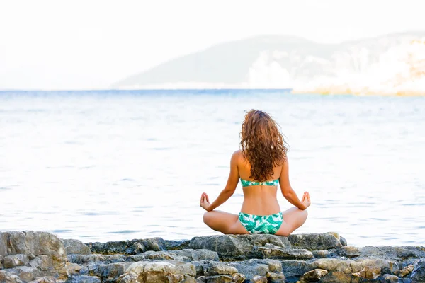 Weiblicher Körper in Yoga-Meditation poze auf den Rochen — Stockfoto