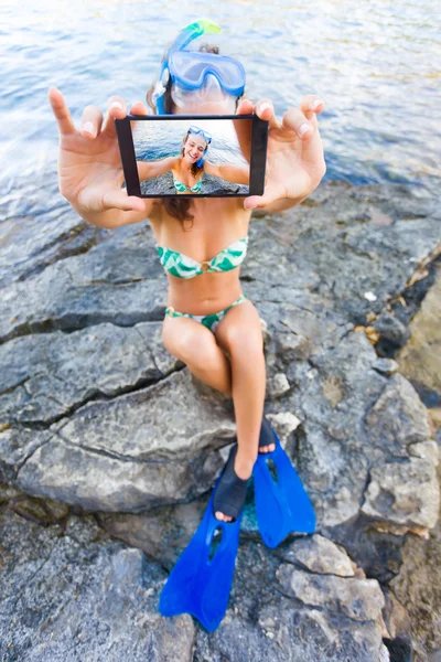 Woman taking a selfie on the rocky shores — Stock fotografie