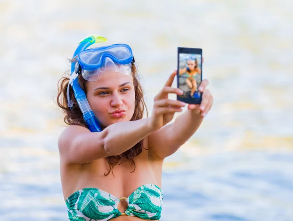 Woman taking a selfie on the rocky shores — Stok fotoğraf