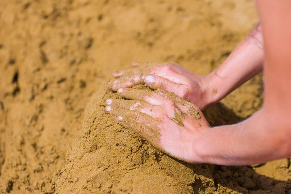 Женские руки играют с песком — стоковое фото