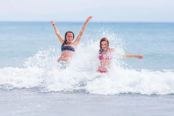 Women with suntan splashed by the waves — Stock Fotó