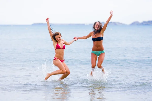 Women jumping in the sea water — Stock fotografie