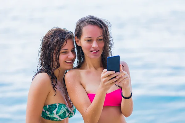 Girls photographing themselves on the beach — Stock Photo, Image