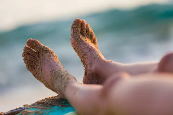 Vrouwelijke voeten rusten op de zonnebank — Stockfoto
