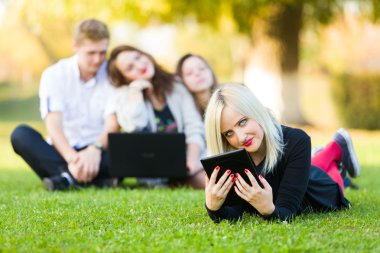 kadınla çimenlerin üzerinde bir tablet