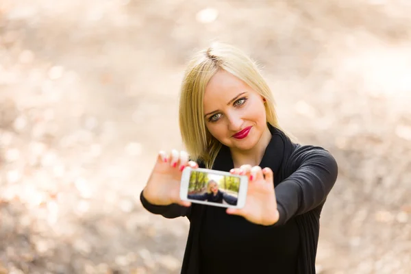 Menina tomando uma selfie com seu smartphone — Fotografia de Stock