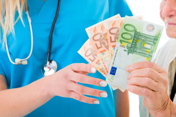 Senior vrouw zeep geld geven aan arts — Stockfoto