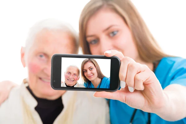 Äldre patienten och unga läkare själv porträtt — Stockfoto