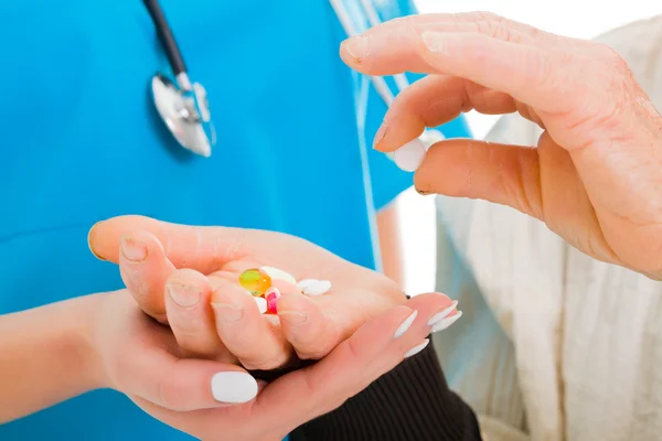 Vecchia donna raccogliendo una pillola con il medico — Foto Stock