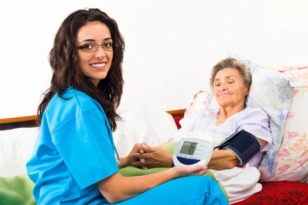 Медсестра использует цифровое кровяное давление для пациента — стоковое фото