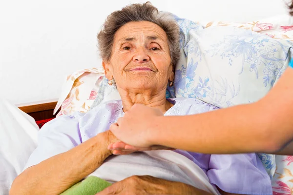 Pielęgniarka trzymająca starszą kobietę za rękę — Zdjęcie stockowe