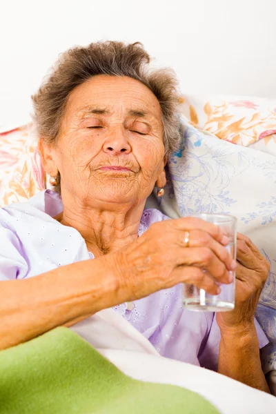 Senhora idosa tomando medicamentos — Fotografia de Stock