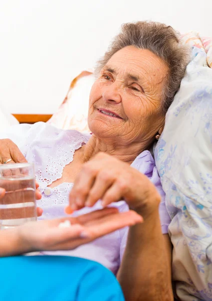 Medicamentos administrados a mujeres mayores en la cama — Foto de Stock