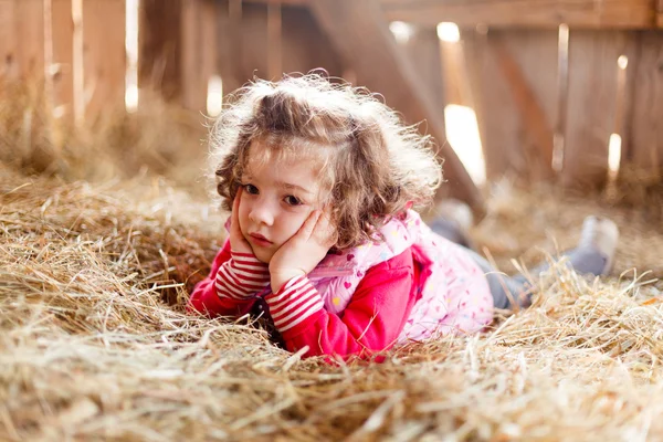 女孩躺在干草棚里的卷发 — 图库照片