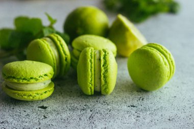 Kurabiyeler. Yeşil kireç ve nane yapraklı kurabiye. Lezzetli Fransız tatlıları. Makarnalar masaya.