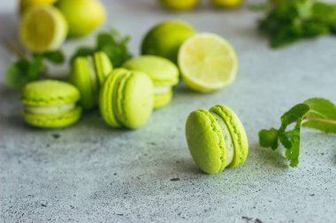 Kurabiyeler. Yeşil kireç ve nane yapraklı kurabiye. Lezzetli Fransız tatlıları. Makarnalar masaya.