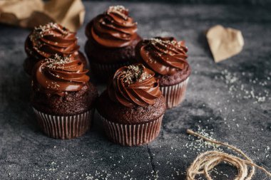 Lezzetli çikolatalı kekler. Kekler beton masada. Çikolatalı bisküvi ve çikolatalı ganache.