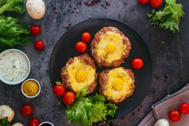 Tabakta yumurtalı biftek. Lezzetli sıcak yemek. Yemek kiraz domatesleri ve otlarla süslenmiş. Tabakta biftek. 