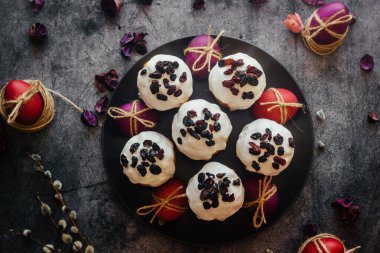 Paskalya pastası. Paskalya için geleneksel bir Ortodoks yemeği. Kurutulmuş kayısı, kuru üzüm ve kremalı Paskalya pastaları. Boyalı yumurtalarla Paskalya kompozisyonu 