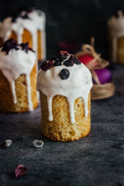 Paskalya pastası. Paskalya için geleneksel bir Ortodoks yemeği. Kurutulmuş kayısı, kuru üzüm ve kremalı Paskalya pastaları. Boyalı yumurtalarla Paskalya kompozisyonu 