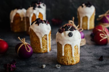 Paskalya pastası. Paskalya için geleneksel bir Ortodoks yemeği. Kurutulmuş kayısı, kuru üzüm ve kremalı Paskalya pastaları. Boyalı yumurtalarla Paskalya kompozisyonu 