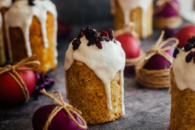 Paskalya pastası. Paskalya için geleneksel bir Ortodoks yemeği. Kurutulmuş kayısı, kuru üzüm ve kremalı Paskalya pastaları. Boyalı yumurtalarla Paskalya kompozisyonu 