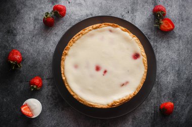 Delicious pie with strawberries and cream. Pie on the table. Pie with berries on a plate