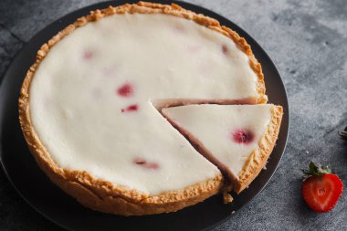 Delicious pie with strawberries and cream. Pie on the table. Pie with berries on a plate
