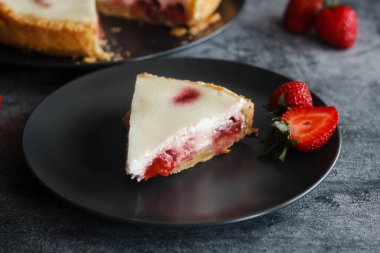 Delicious pie with strawberries and cream. Pie on the table. Pie with berries on a plate
