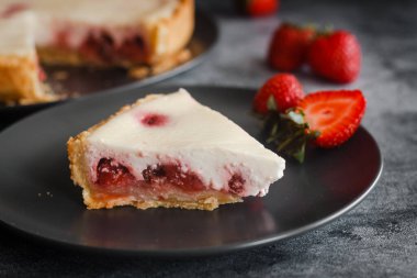 Delicious pie with strawberries and cream. Pie on the table. Pie with berries on a plate