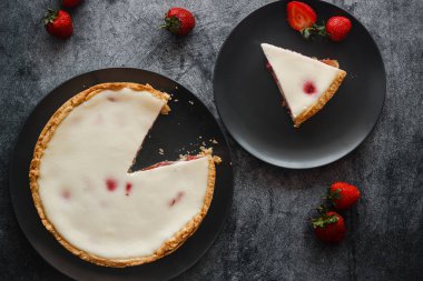 Delicious pie with strawberries and cream. Pie on the table. Pie with berries on a plate