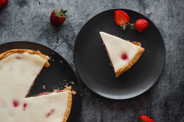 Delicious pie with strawberries and cream. Pie on the table. Pie with berries on a plate