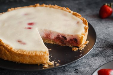 Delicious pie with strawberries and cream. Pie on the table. Pie with berries on a plate