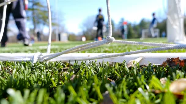 Los niños jugando fútbol juego, cámara detrás de la red de gol — Vídeo de stock