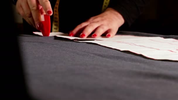 Дизайнер, измеряющий ткань с помощью резака для шитья — стоковое видео