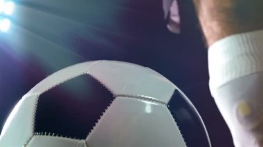 Futbolcu bacağı bir top, siyah arka plan üzerine koyarak Boots