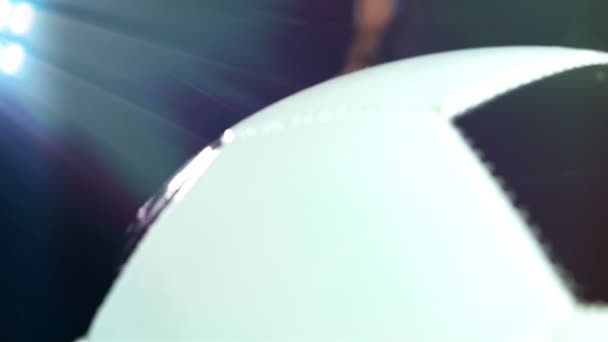 Voetballer in zijn been te zetten door de achtergrond van een bal, zwarte laarzen — Stockvideo
