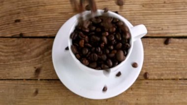 Eski ahşap masa, üstten görünüm bir bardağa kahve çekirdekleri dökme