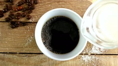 Bir fincan kahve eski ahşap masa, üstten görünüm içine süt dökme