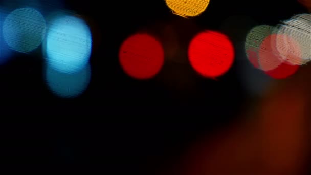 Defocused night traffic lights through wet windscreen — Stock Video