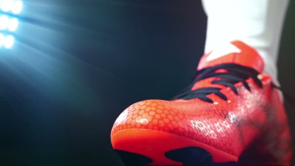 Fútbol, juego de fútbol. Profesional futbolista hebilla de sus zapatos rojos, fondo negro — Vídeo de stock