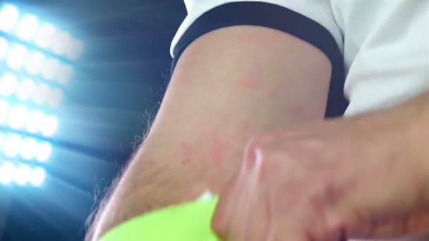 Fotboll, fotbollsspel. Professionell fotbollsspelare i vit outfit sätta kapten tejp, svart bakgrund — Stockvideo