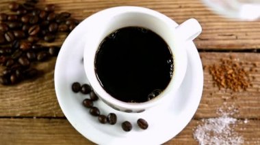 Ağır çekim bir fincan kahve eski ahşap masa, üstten görünüm içine dökülen süt