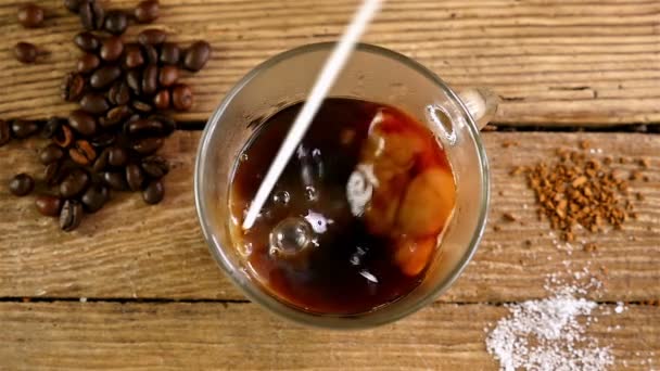 Movimento lento di versare il latte in una tazza di caffè su un vecchio tavolo di legno, vista dall'alto — Video Stock