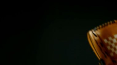 Beyzbol oyuncu ile eldiven ve topu siyah bir arka plan ağır çekim