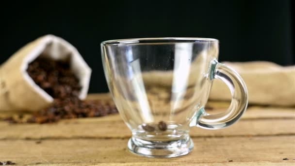 Lento movimiento de verter granos de café en una taza sobre una vieja mesa de madera — Vídeos de Stock