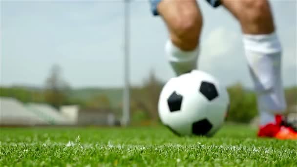 Movimiento lento de pies de futbolista regateando una pelota delante de la cámara — Vídeos de Stock