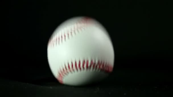 Baseball ball on a black background, slow motion — Stock Video