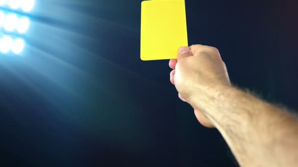 Football / soccer referee shows penalty yellow card, slow motion