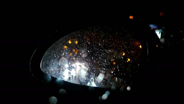 Defocused night traffic lights through wet sideview mirror — Stock Video